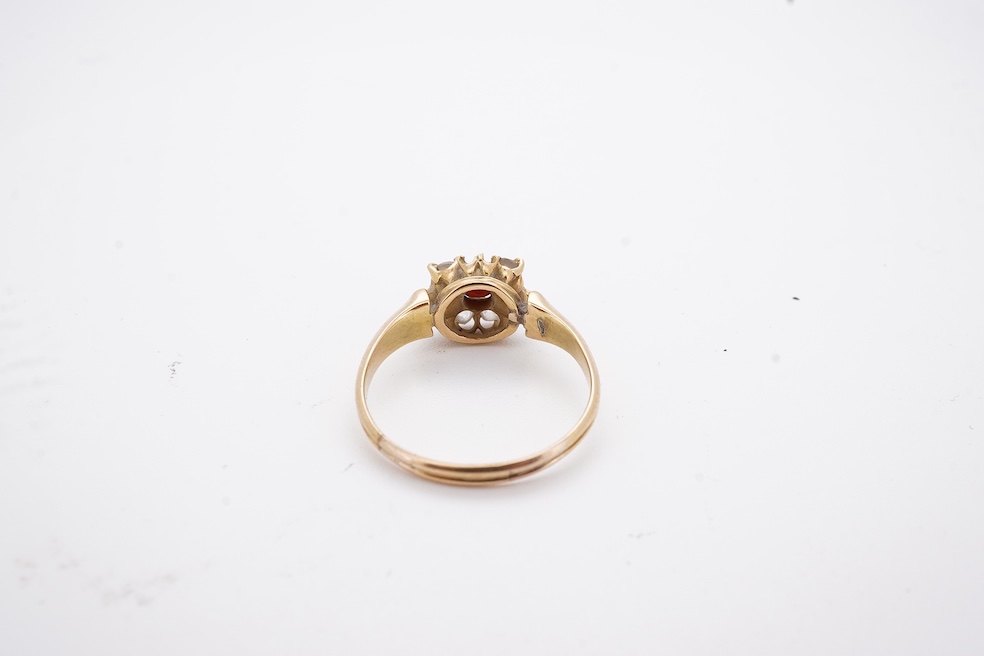 A yellow metal, garnet? and diamond set circular cluster ring (one stone missing), size P, gross weight 3 grams. Condition - poor